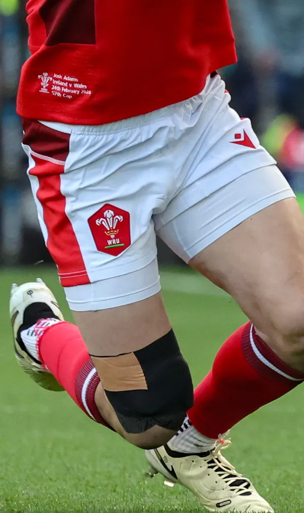 Male rugby player wearing shorts running on the pitch