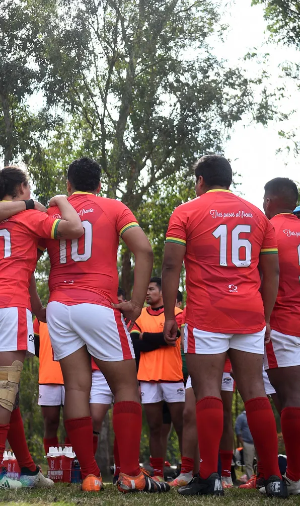 A mens rugby team huddles together during a training game