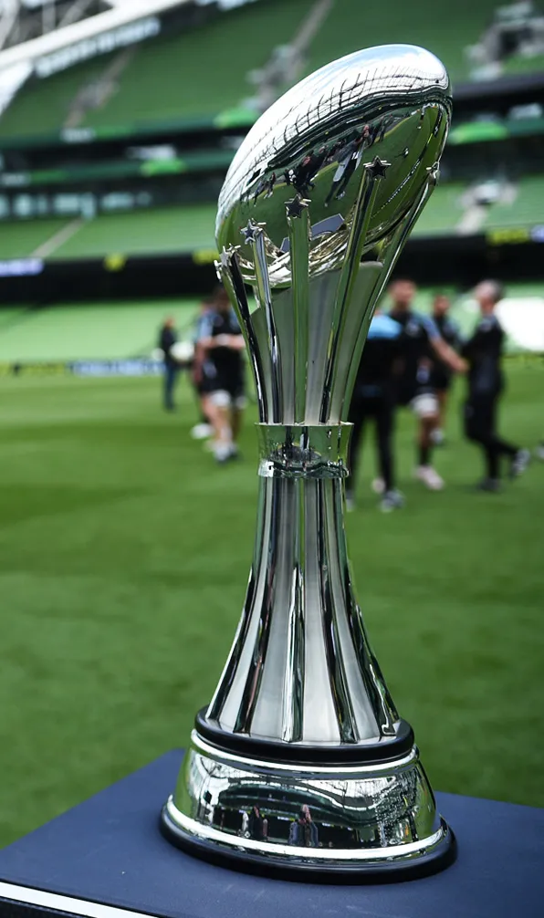 United Rugby Championship The United Rugby Championship trophy sitting on a plinth while players warm up in the background
