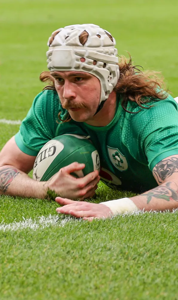 Male rugby player scoring a try wearing a headguard for protection